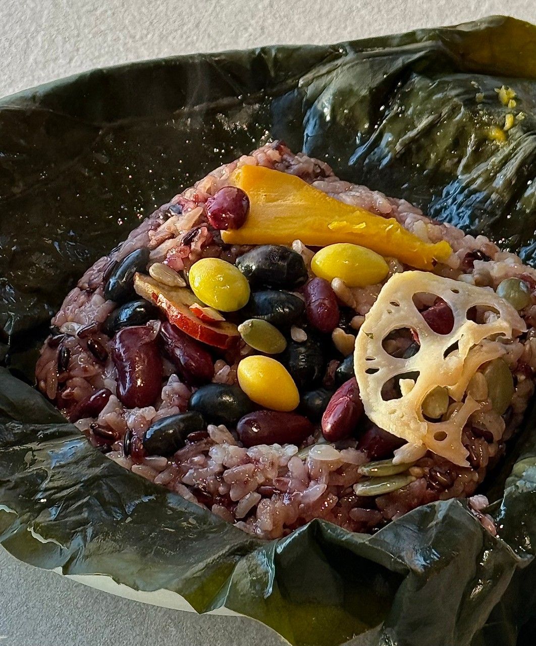 연잎을 펼친 화덕연밥 연잎밥. 콩과 대추, 연근이 올라가 있다
